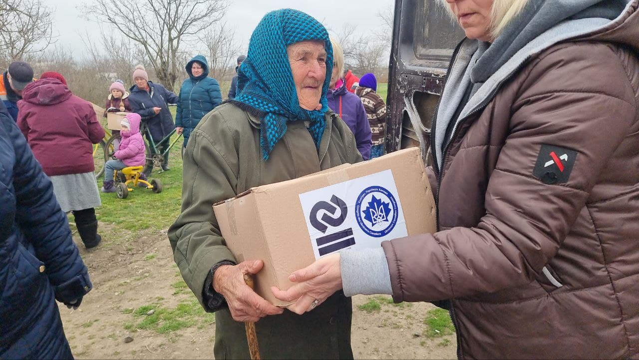 Elderly woman receiving an aid box